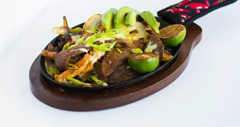 skillet with lime meat and avocado